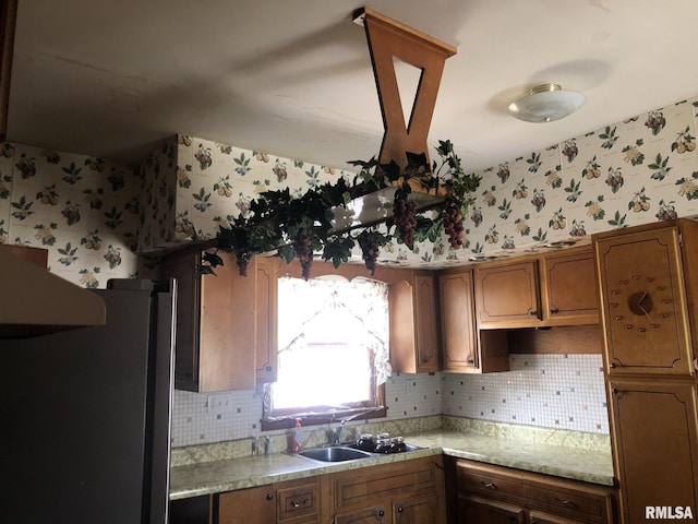 kitchen featuring tasteful backsplash, sink, and stainless steel refrigerator