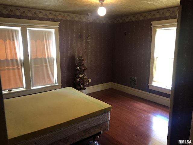 bedroom with hardwood / wood-style flooring and a textured ceiling