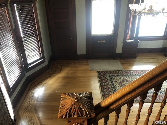 foyer entrance with hardwood / wood-style flooring and a chandelier