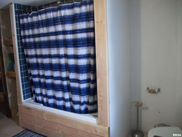 bathroom featuring shower / tub combo and toilet