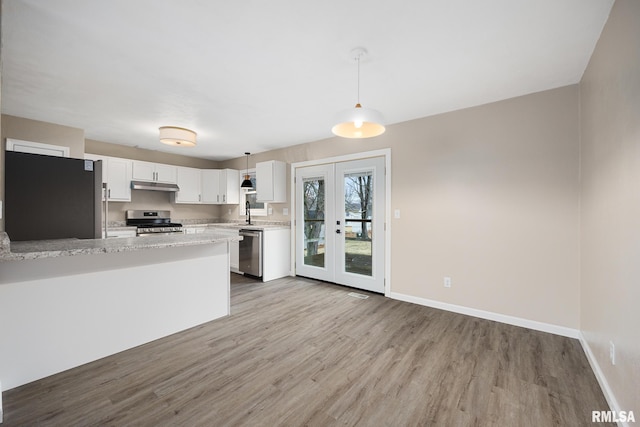 kitchen with pendant lighting, white cabinetry, kitchen peninsula, stainless steel appliances, and french doors