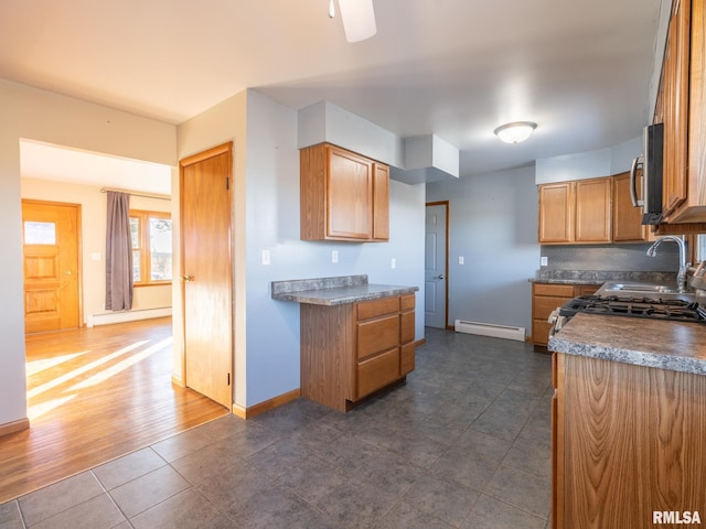 kitchen featuring a baseboard radiator, range, sink, and dark tile patterned floors