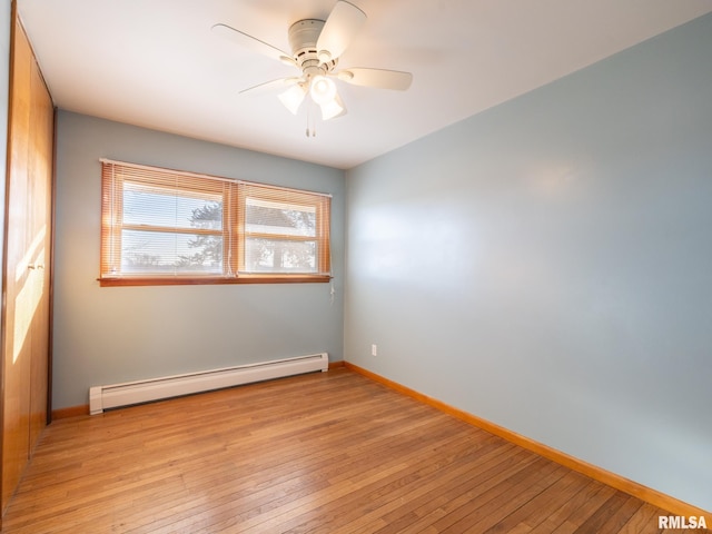 spare room with ceiling fan, light wood-type flooring, and baseboard heating