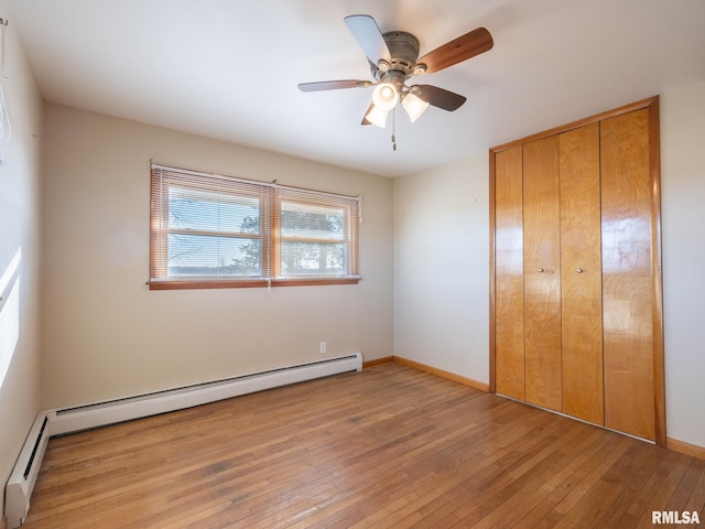 unfurnished bedroom with hardwood / wood-style flooring, ceiling fan, and baseboard heating