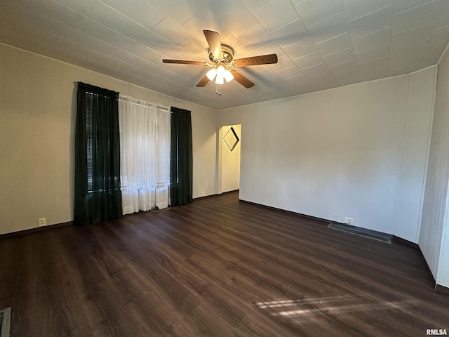 spare room with dark wood-type flooring and ceiling fan