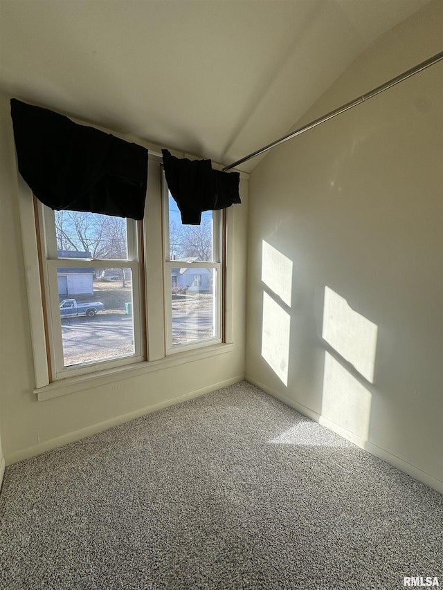 unfurnished room featuring carpet flooring and vaulted ceiling