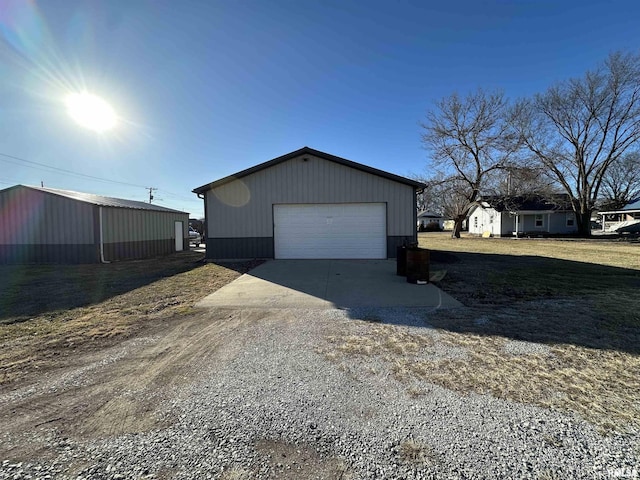 view of side of home featuring a garage and an outbuilding