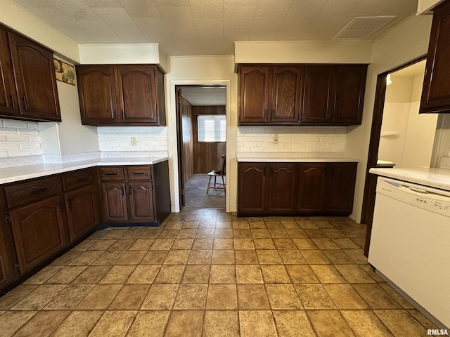 kitchen featuring dishwasher, dark brown cabinets, and backsplash