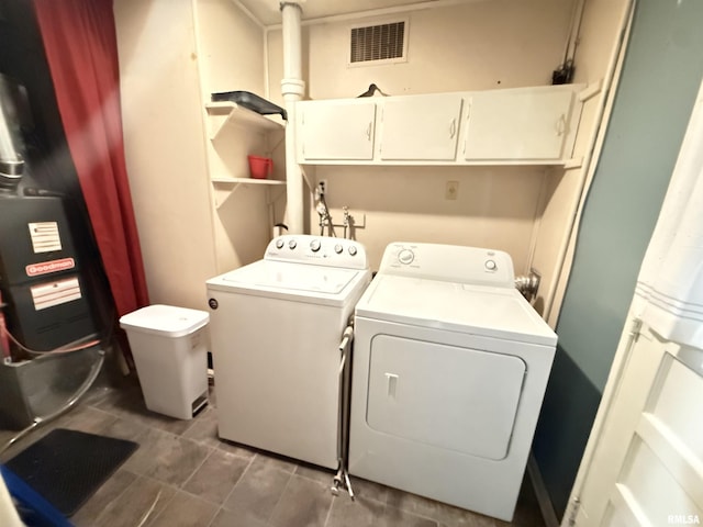 laundry area featuring washing machine and dryer and cabinets