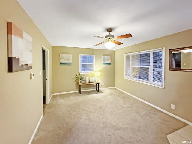 carpeted spare room featuring ceiling fan