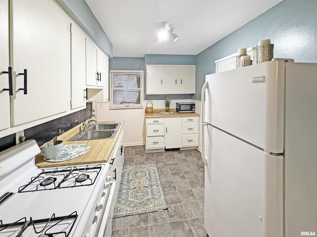 kitchen featuring white cabinetry, white appliances, and sink