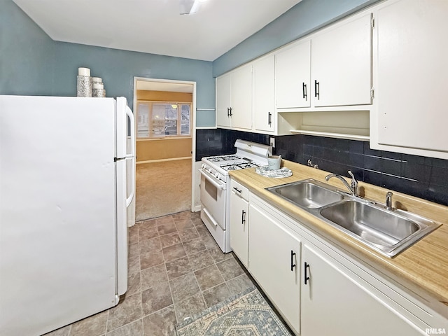 kitchen with white appliances, sink, decorative backsplash, and white cabinets