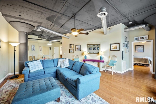 living room featuring ceiling fan and light hardwood / wood-style flooring