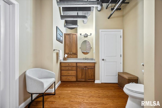 316 SW Washington St Unit 603, Peoria, IL 61602 - bathroom featuring wood finished floors, vanity, toilet, and baseboards