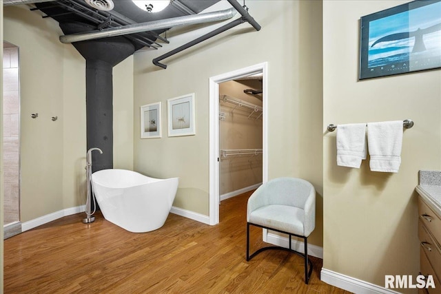 bathroom featuring hardwood / wood-style flooring, vanity, and a washtub