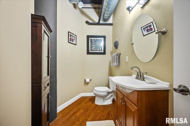 bathroom with vanity, hardwood / wood-style flooring, and toilet