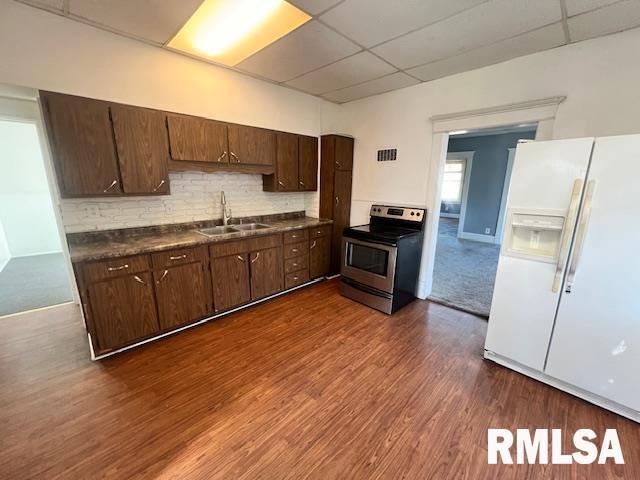 kitchen featuring stainless steel electric stove, a paneled ceiling, sink, dark hardwood / wood-style flooring, and white refrigerator with ice dispenser