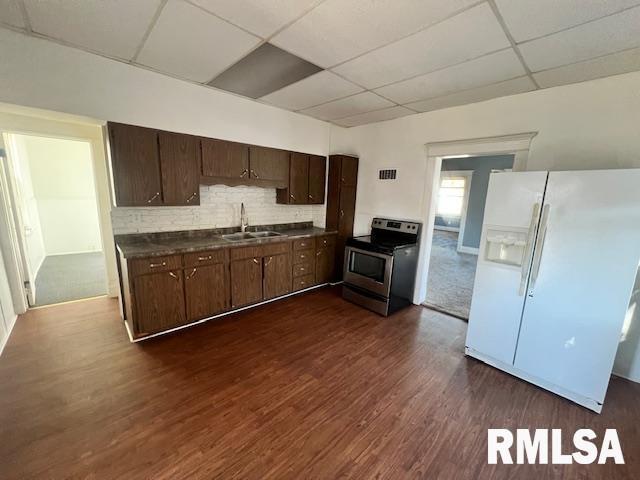 kitchen with electric stove, dark brown cabinetry, white refrigerator with ice dispenser, and sink