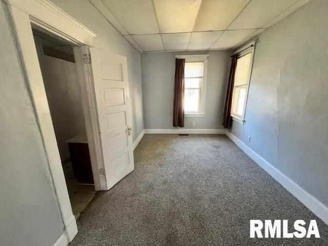 unfurnished bedroom with carpet flooring and a drop ceiling