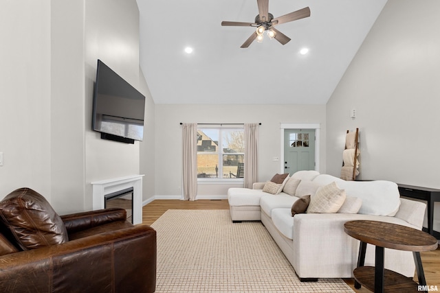 living room featuring high vaulted ceiling, ceiling fan, and light wood-type flooring