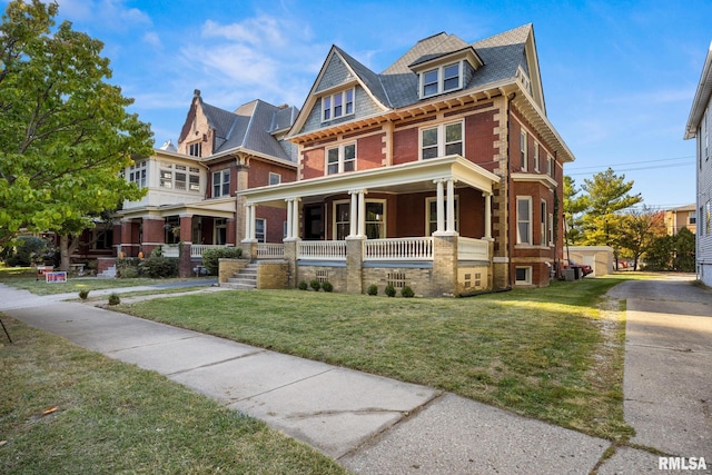 view of front of house with central AC unit, a front yard, and covered porch