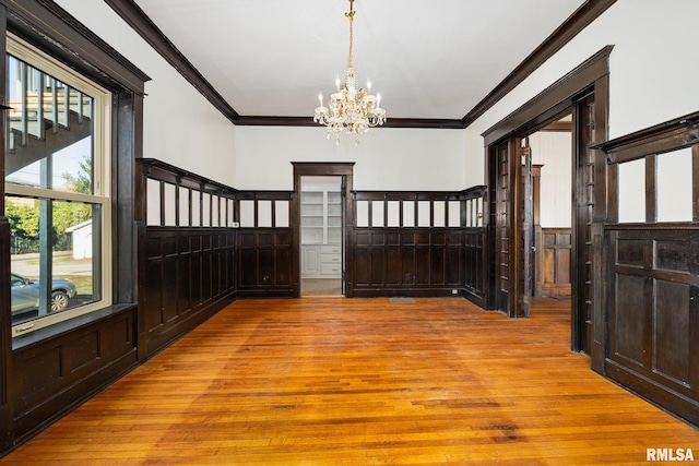 entrance foyer featuring crown molding, a notable chandelier, and light wood-type flooring