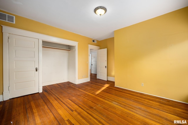 unfurnished bedroom with hardwood / wood-style flooring and a closet