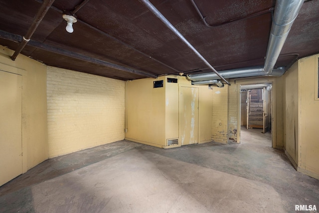 basement featuring brick wall