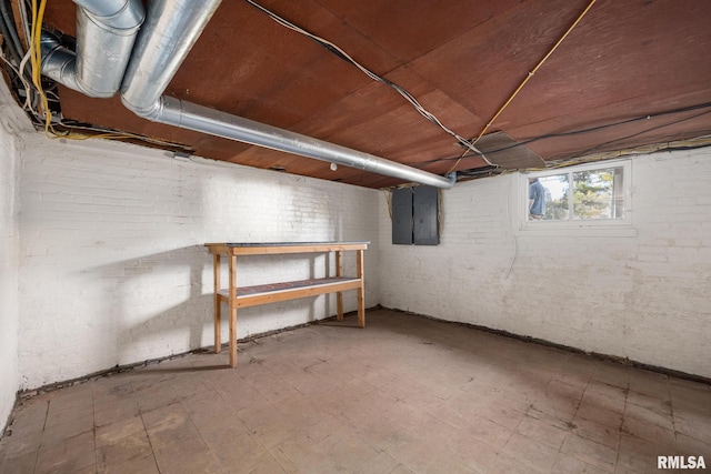 basement featuring brick wall and electric panel