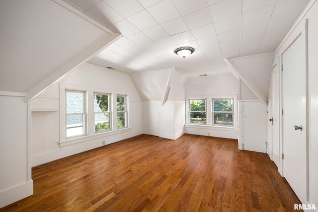 bonus room with lofted ceiling and dark hardwood / wood-style floors