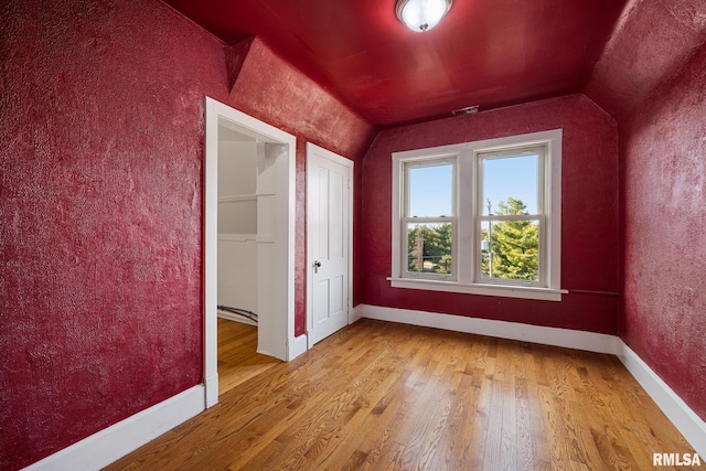 bonus room with vaulted ceiling and hardwood / wood-style floors