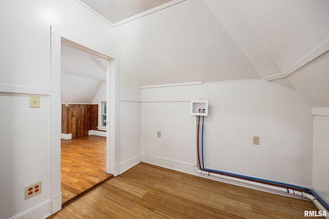 bonus room with wood-type flooring and vaulted ceiling