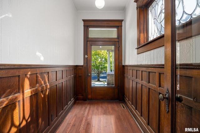 entryway with dark wood-type flooring and ornamental molding