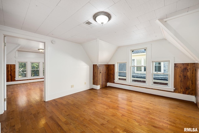 additional living space featuring lofted ceiling and hardwood / wood-style floors