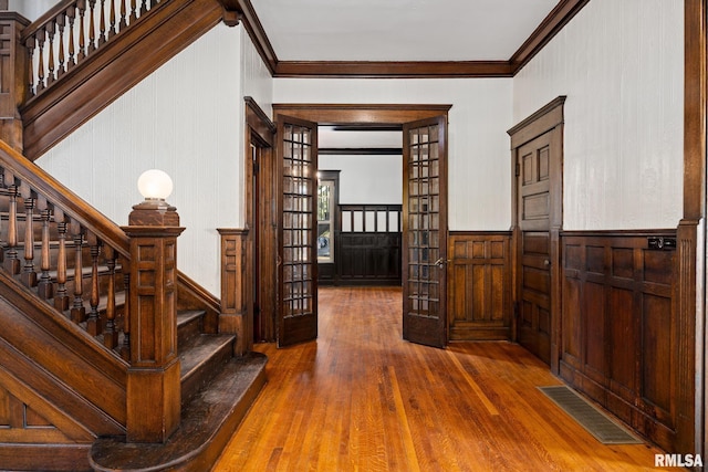 interior space featuring ornamental molding, hardwood / wood-style floors, and french doors