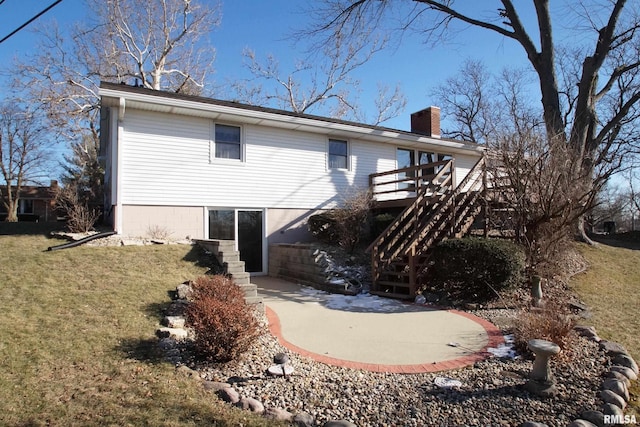 rear view of property featuring a wooden deck, a patio area, and a lawn