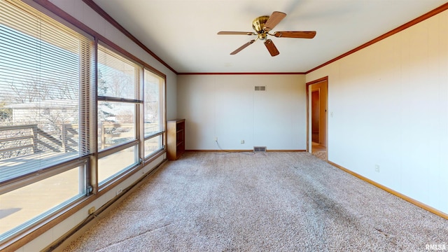 spare room with light carpet, ornamental molding, and ceiling fan