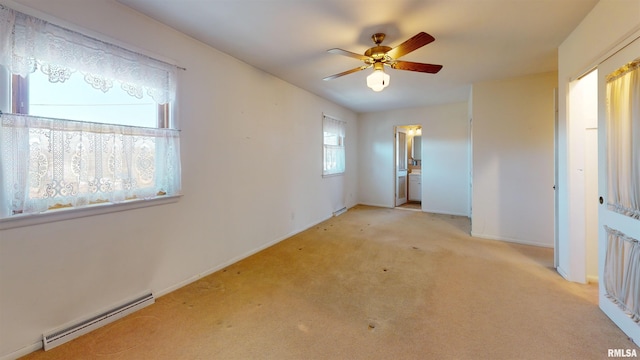 empty room featuring a baseboard heating unit, light carpet, and ceiling fan