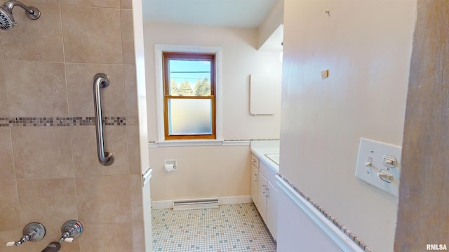 bathroom featuring vanity, tile patterned floors, and tiled shower