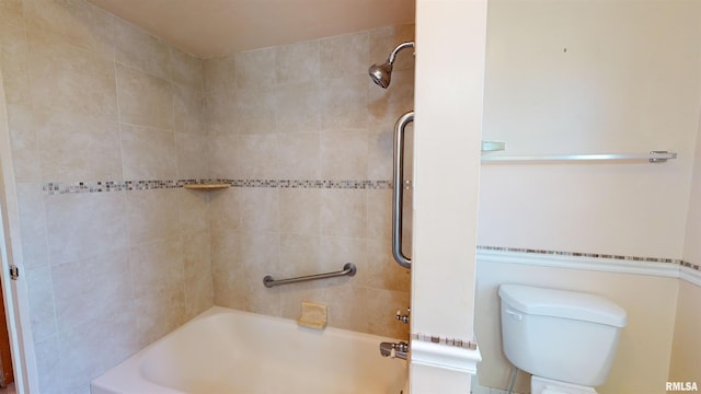 bathroom with toilet and tiled shower / bath