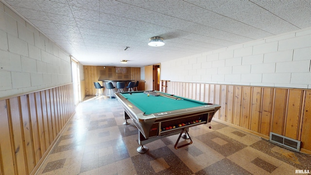 game room featuring wooden walls, billiards, and indoor bar