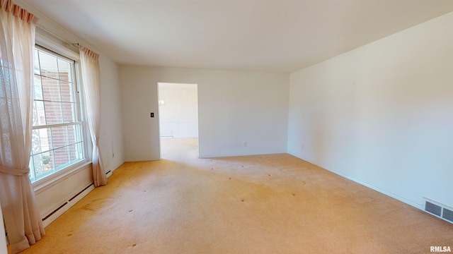 spare room with a baseboard heating unit and light colored carpet