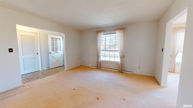 carpeted empty room featuring baseboard heating