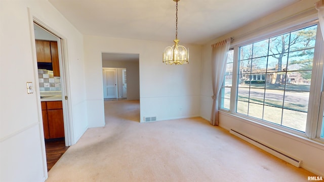 carpeted spare room featuring a notable chandelier, a baseboard radiator, and plenty of natural light