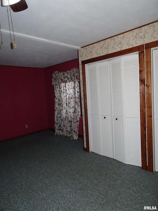 unfurnished bedroom with dark carpet and ceiling fan