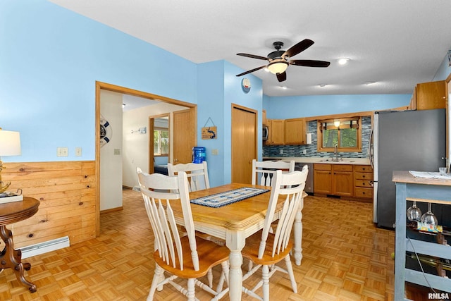 dining room with ceiling fan, light parquet flooring, lofted ceiling, and sink