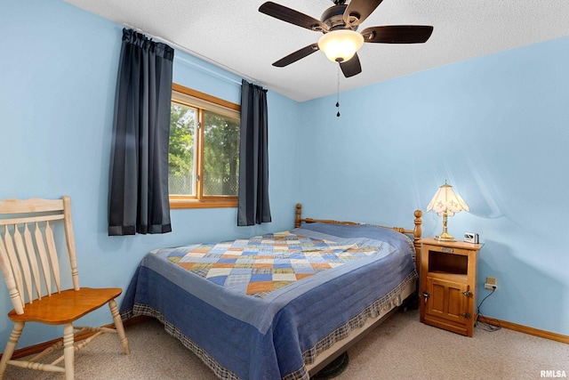 carpeted bedroom featuring ceiling fan and a textured ceiling