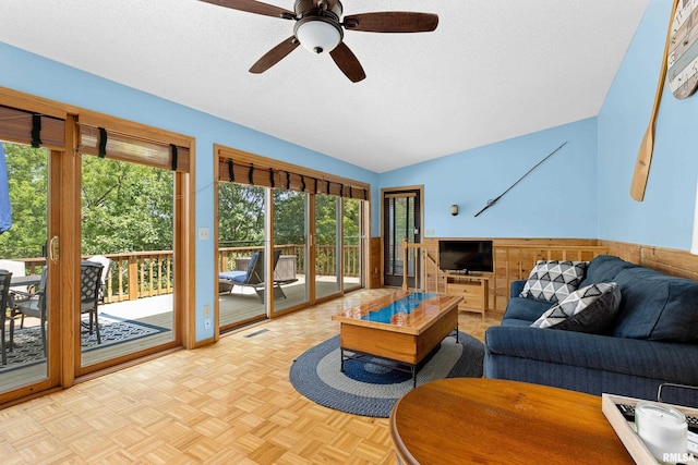 living room featuring light parquet floors, ceiling fan, lofted ceiling, and a textured ceiling