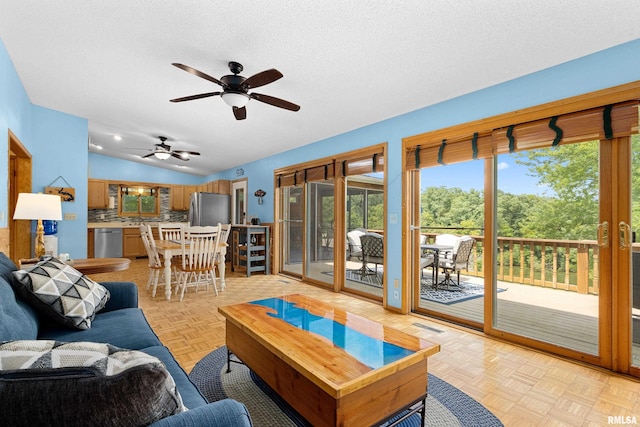 living room with lofted ceiling, a textured ceiling, and light parquet flooring