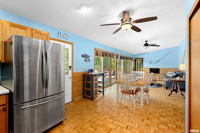 kitchen with stainless steel refrigerator, light parquet flooring, and a textured ceiling